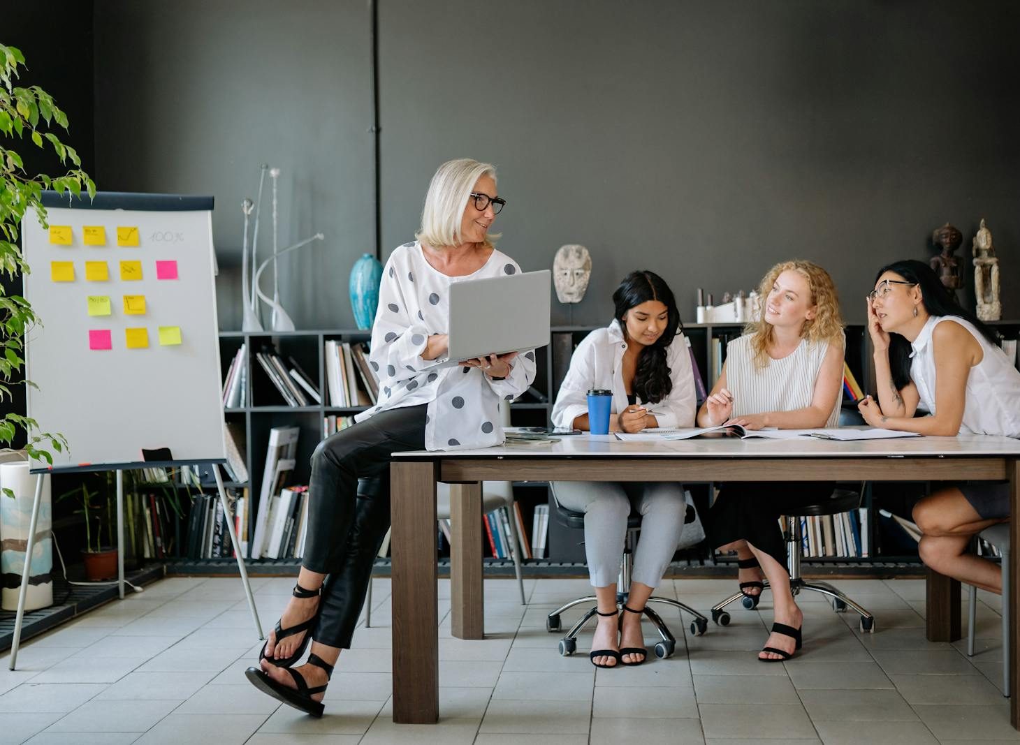 Four women collaborate in a modern office space, fostering teamwork and discussion.